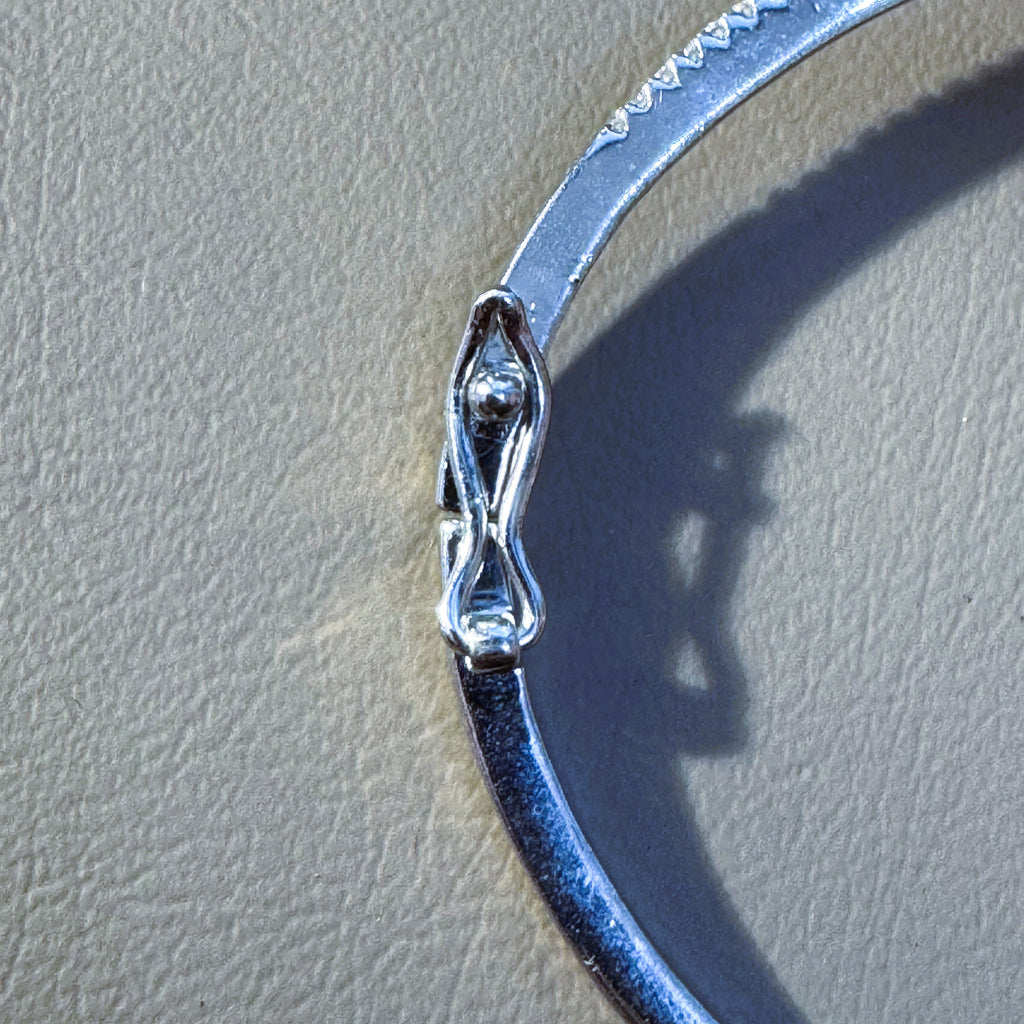 The hinge and box clasp on the plain polished half of the bangle.