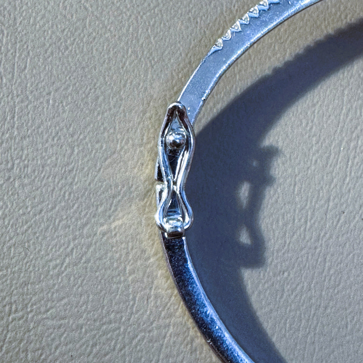 The hinge and box clasp on the plain polished half of the bangle.