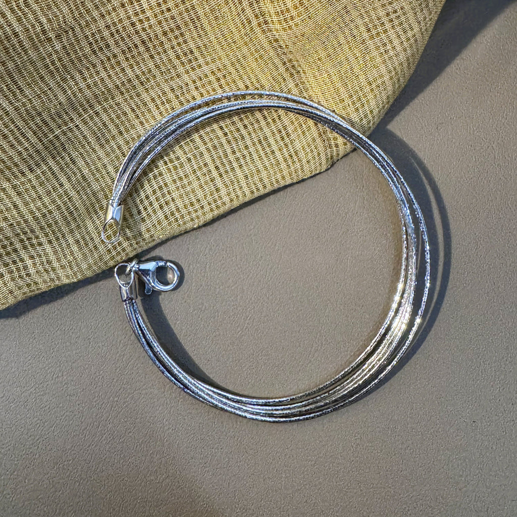 Five-strand sterling silver omega chain bracelet laid in a circle with the lobster clasp open.