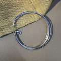 Five-strand sterling silver omega chain bracelet laid in a circle with the lobster clasp open.