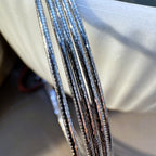 Close view of the five faceted omega chain strands of the silver bracelet.