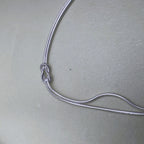 The two snake chains of the bracelet running side by side to the knot.