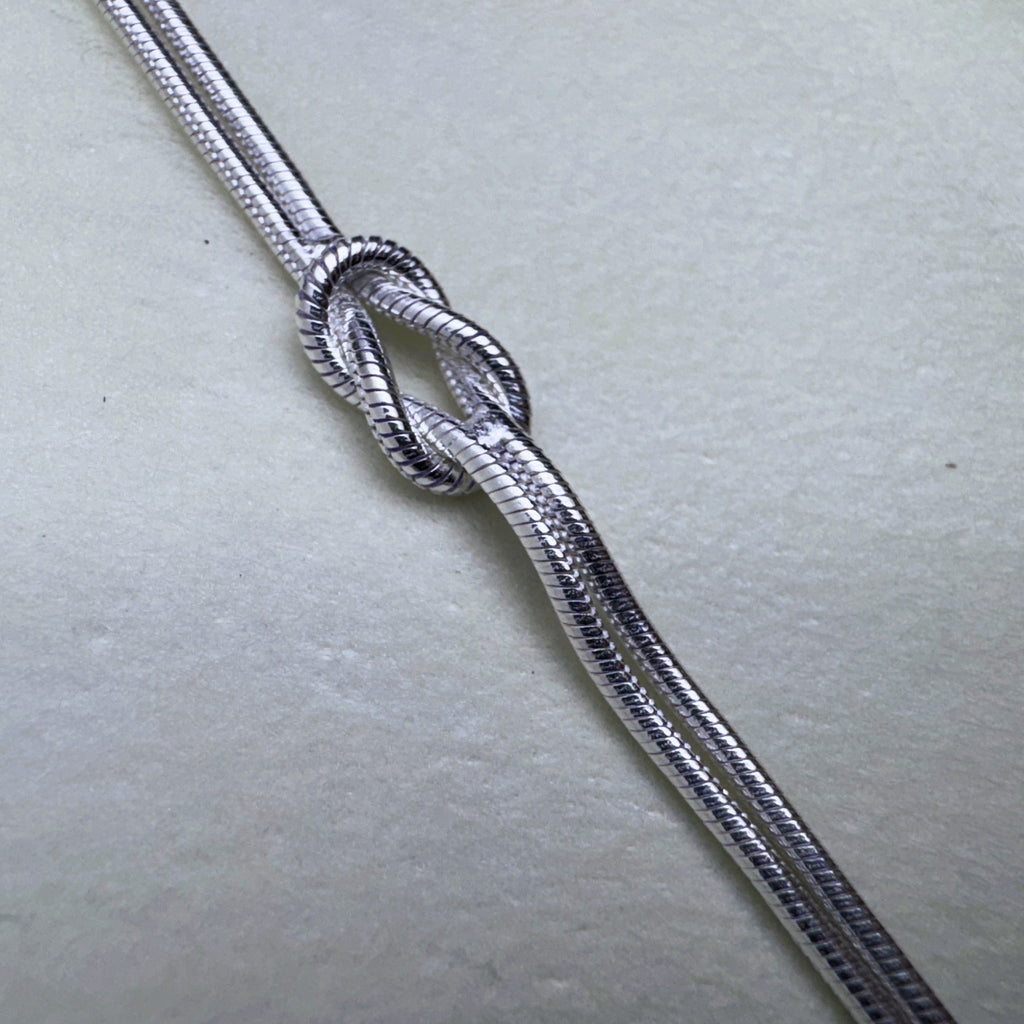 Close view of the knot and the fine texture of the snake chains.
