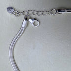 The lobster clasp, the extender chain and the 925 tag of the silver bracelet.