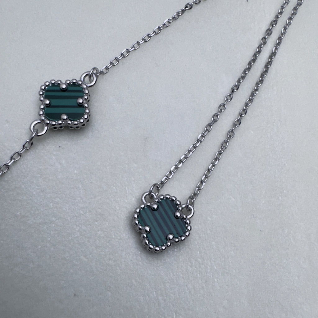 The green clover bracelet beside the matching necklace.