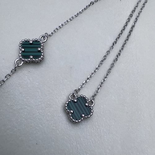 The green clover bracelet beside the matching necklace.