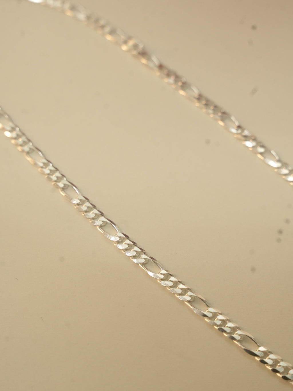 Close view of the figaro links, three short links followed by one long link.