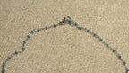 Close view of the spring-ring clasp and turquoise-blue beaded sections of the sterling silver shell chain.