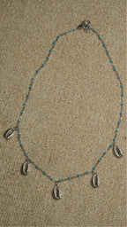 Full view of the beaded sterling silver chain with cubic zirconia-set shell charms spaced along the lower edge.