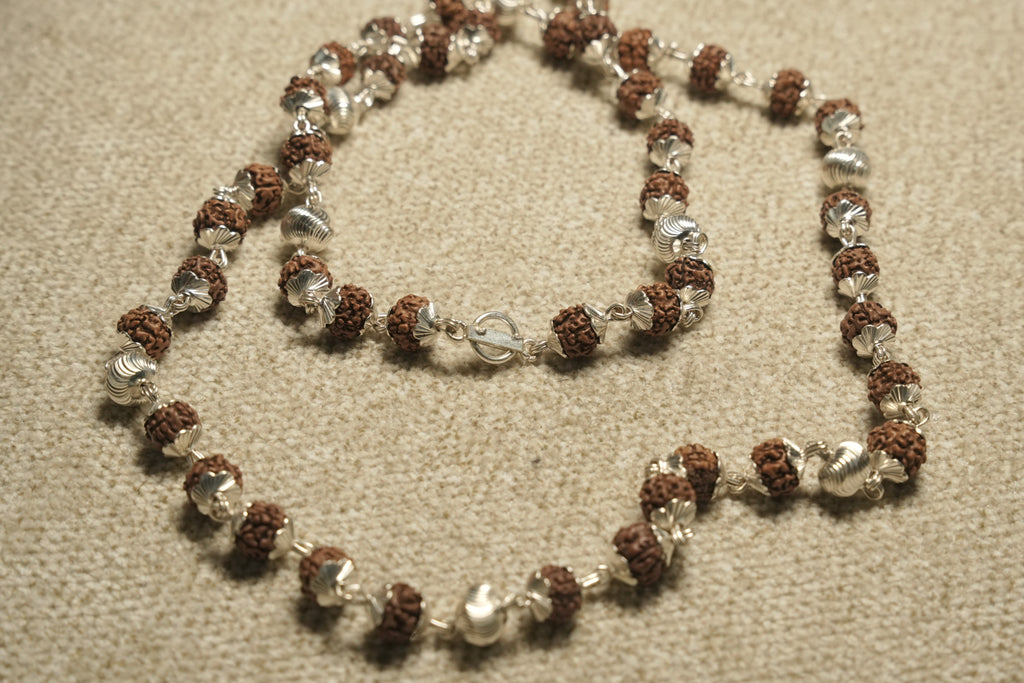 Close view of the Rudraksha chain showing textured beads in fluted sterling silver caps and its bar closure.