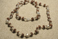 Close view of the Rudraksha chain showing textured beads in fluted sterling silver caps and its bar closure.