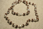 Close view of the Rudraksha chain showing textured beads in fluted sterling silver caps and its bar closure.