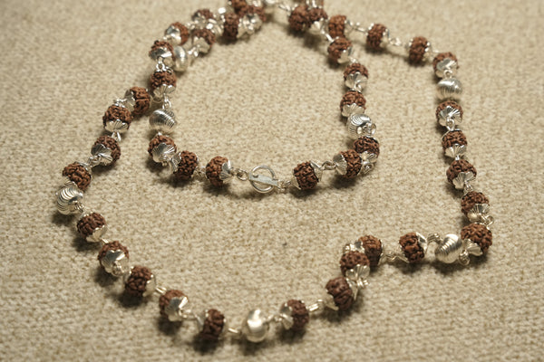 Close view of the Rudraksha chain showing textured beads in fluted sterling silver caps and its bar closure.