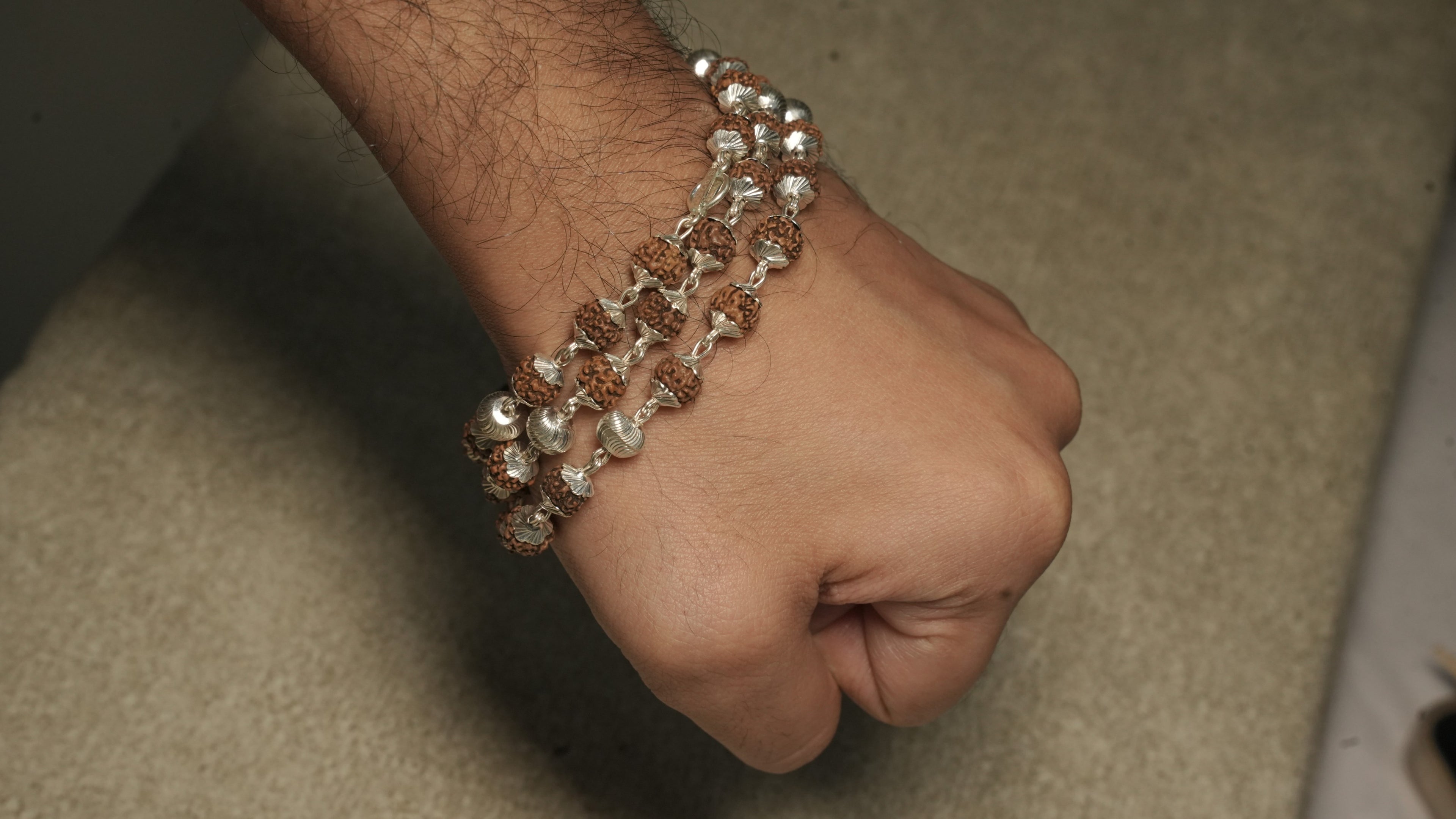 Rudraksha chain in sterling silver worn wrapped in layers around a wrist.