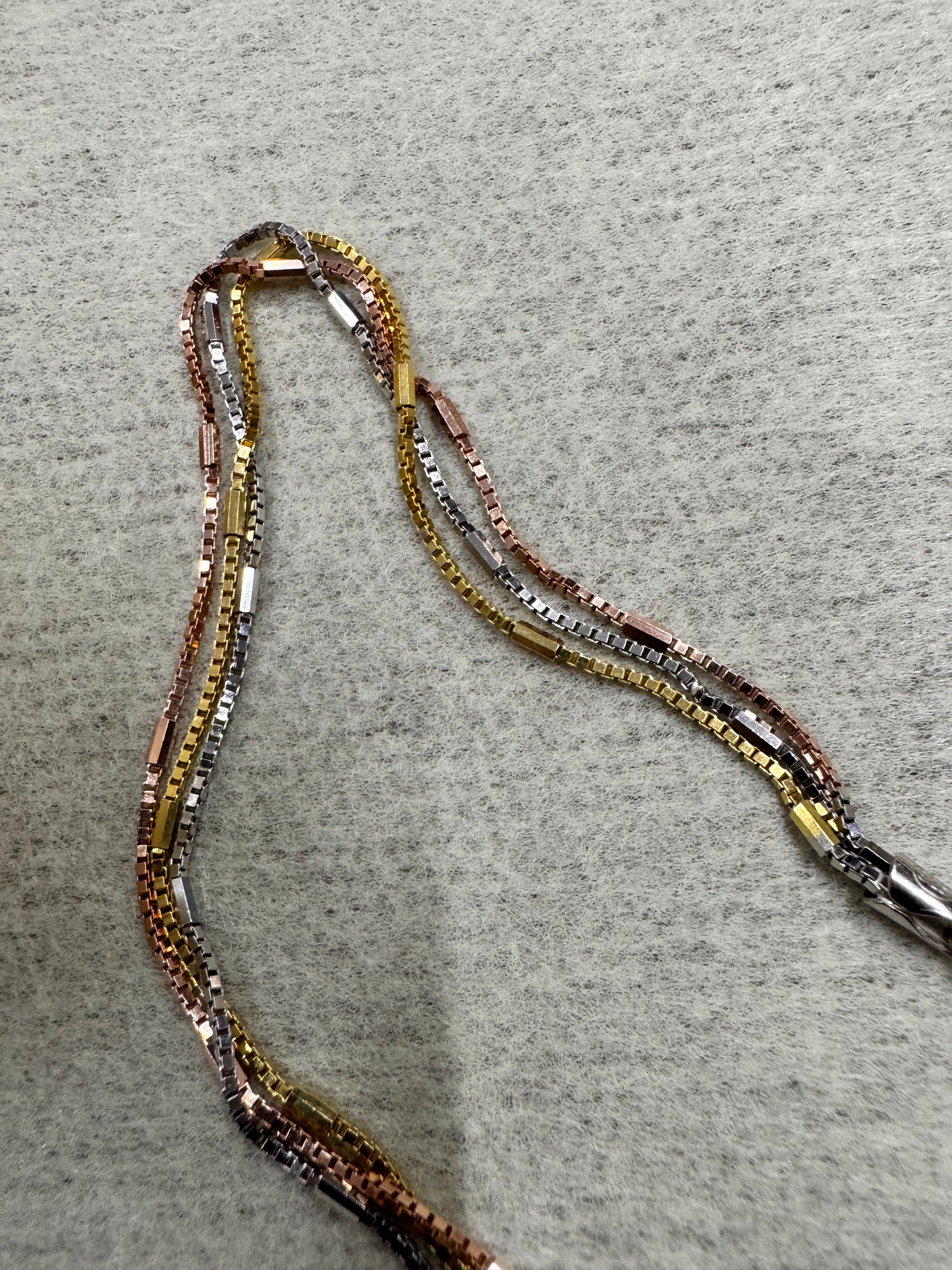 Close view of the strands of the sterling silver box chain necklace, showing the three finishes running side by side.
