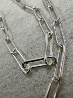 Macro view of the elongated flat links of the sterling silver paperclip chain necklace.