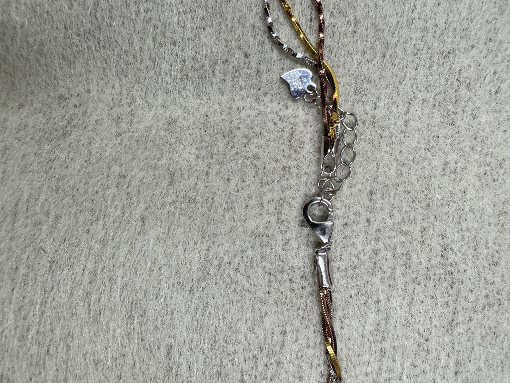 Lobster clasp, extender chain and small heart charm at the fastening of the sterling silver three-strand necklace.