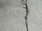 Lobster clasp, extender chain and small heart charm at the fastening of the sterling silver three-strand necklace.