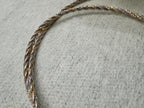 Close view of the twisted sterling silver rope chain, the three tones running along the length of the necklace.