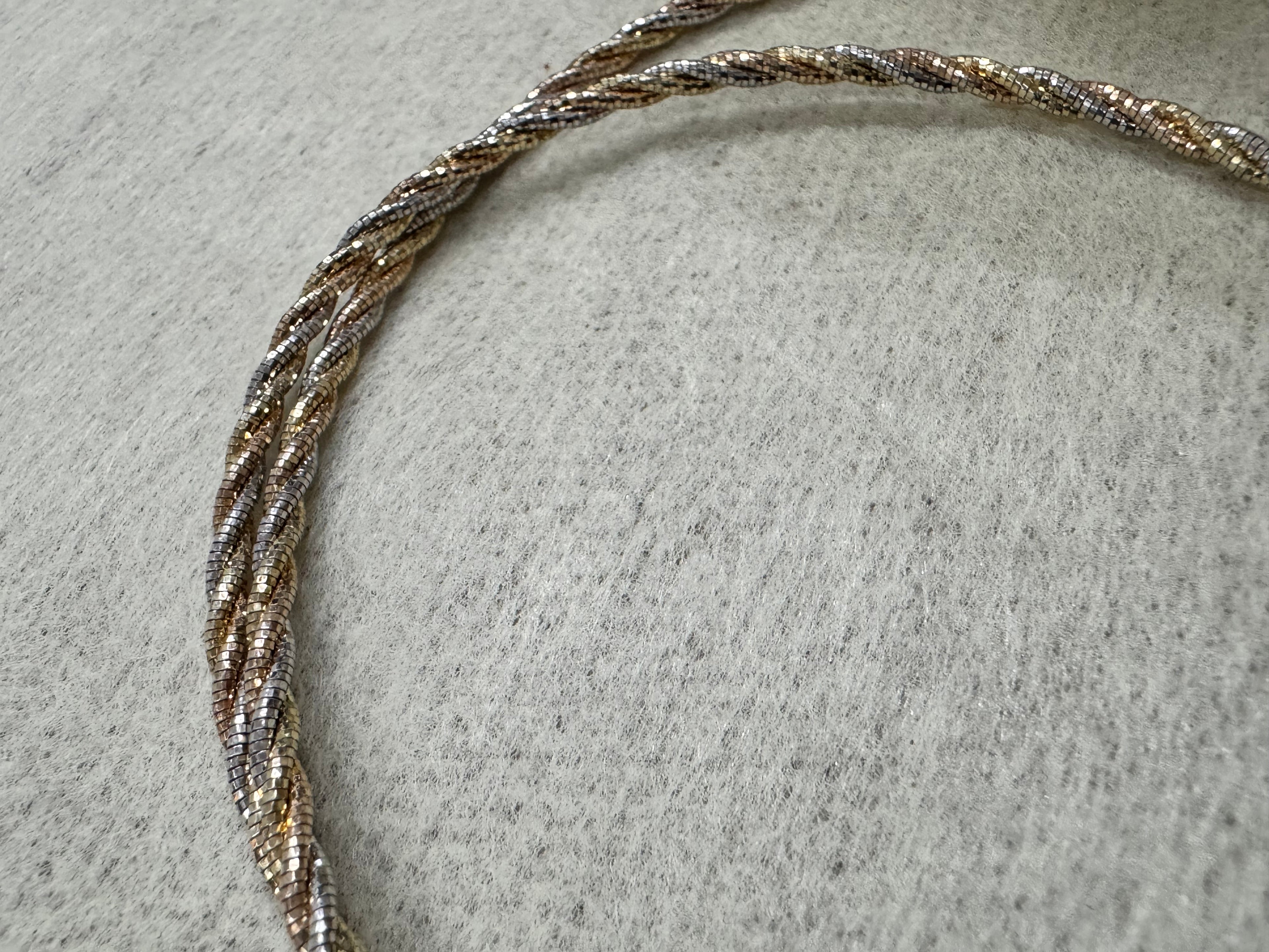Close view of the twisted sterling silver rope chain, the three tones running along the length of the necklace.