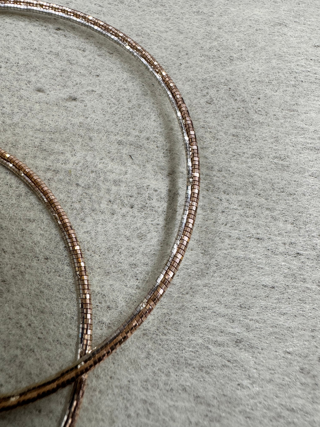 Close view of the round sterling silver snake chain, showing the rose-tone finish and the bright cut faces.