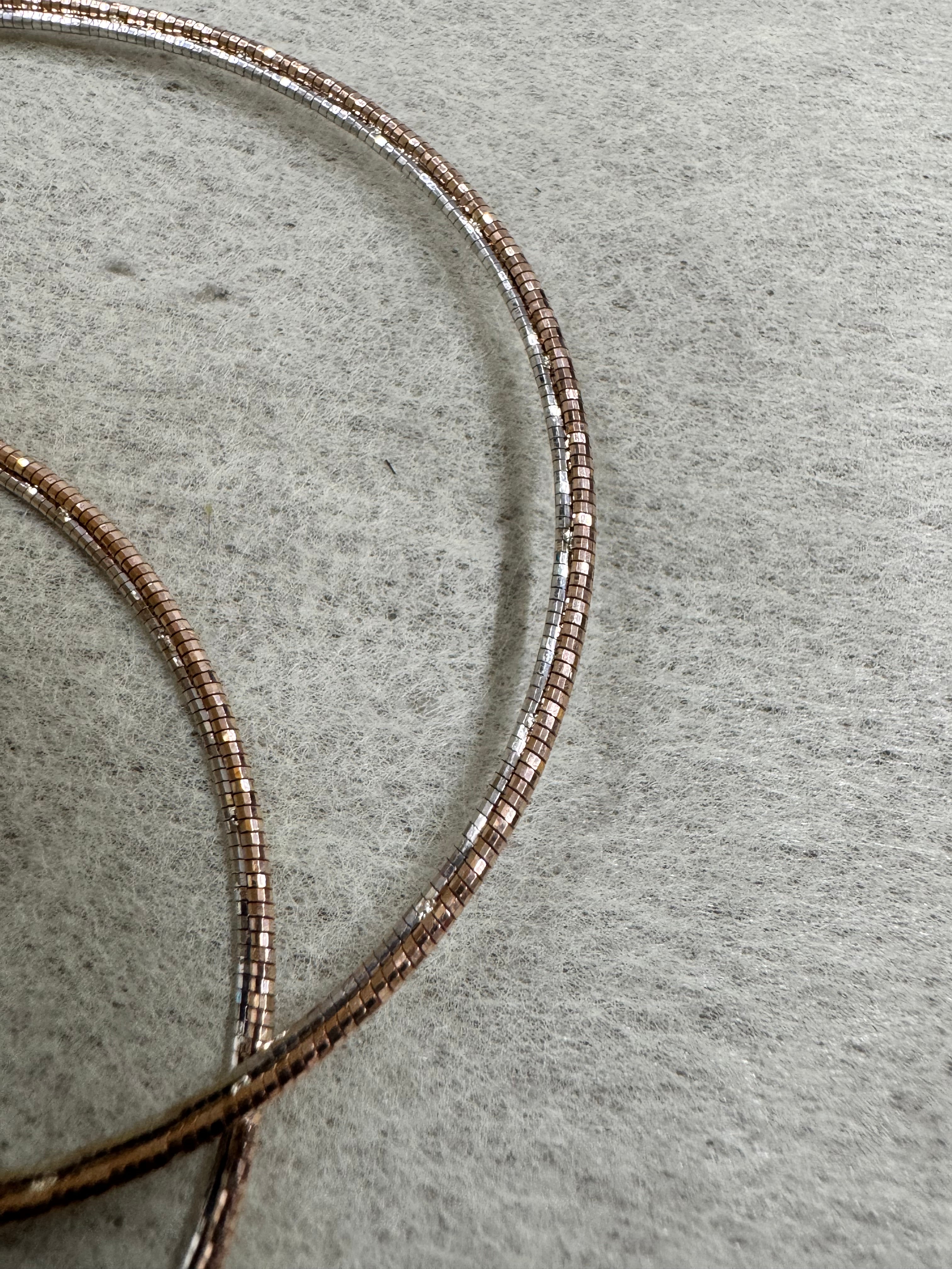 Close view of the round sterling silver snake chain, showing the rose-tone finish and the bright cut faces.
