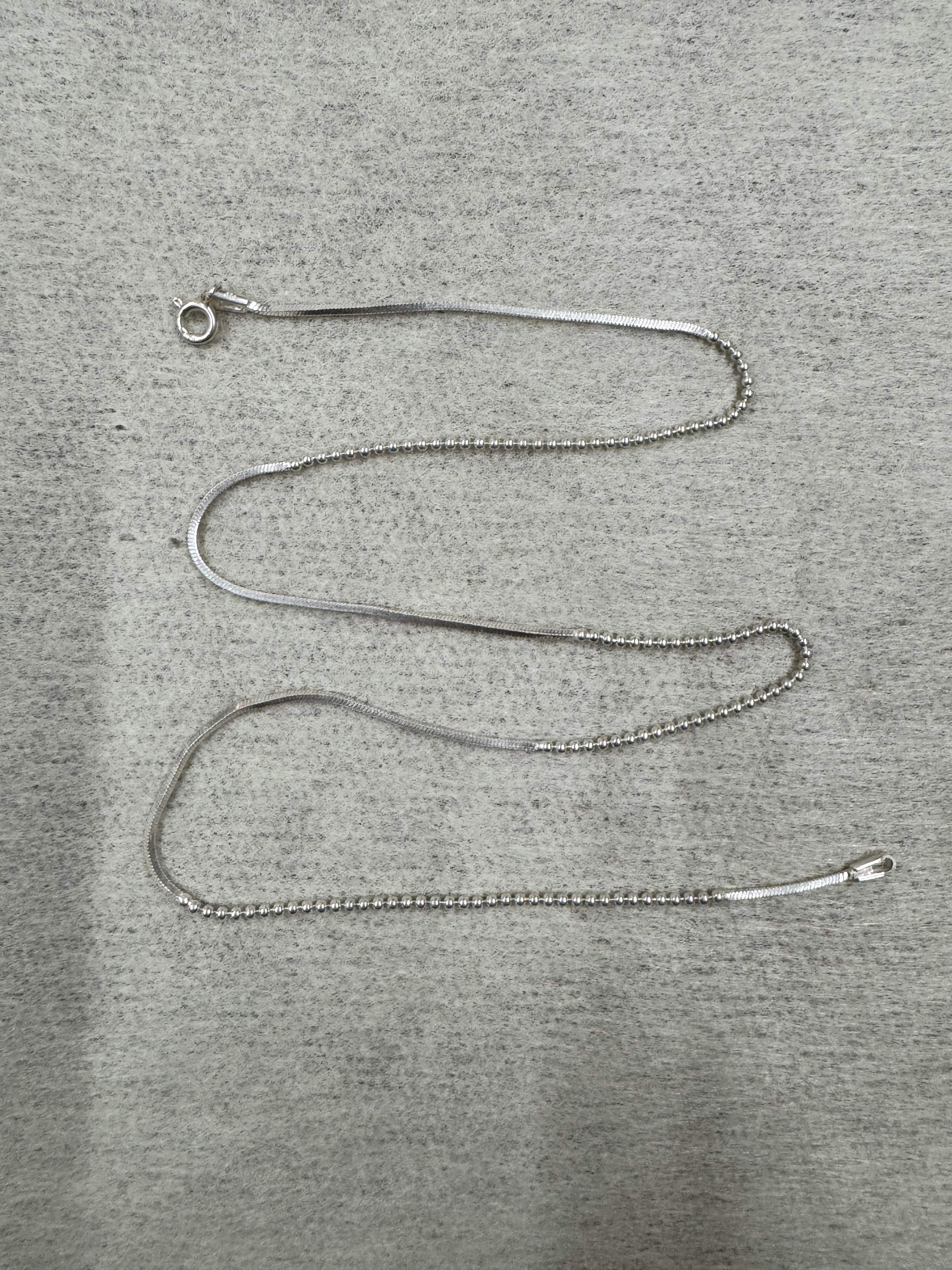 Full 45 cm length of the sterling silver chain necklace laid out on grey felt, showing snake sections alternating with runs of round beads and a spring ring clasp.