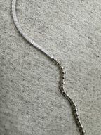 Macro view of the join between the snake chain and the bead section on the sterling silver necklace.