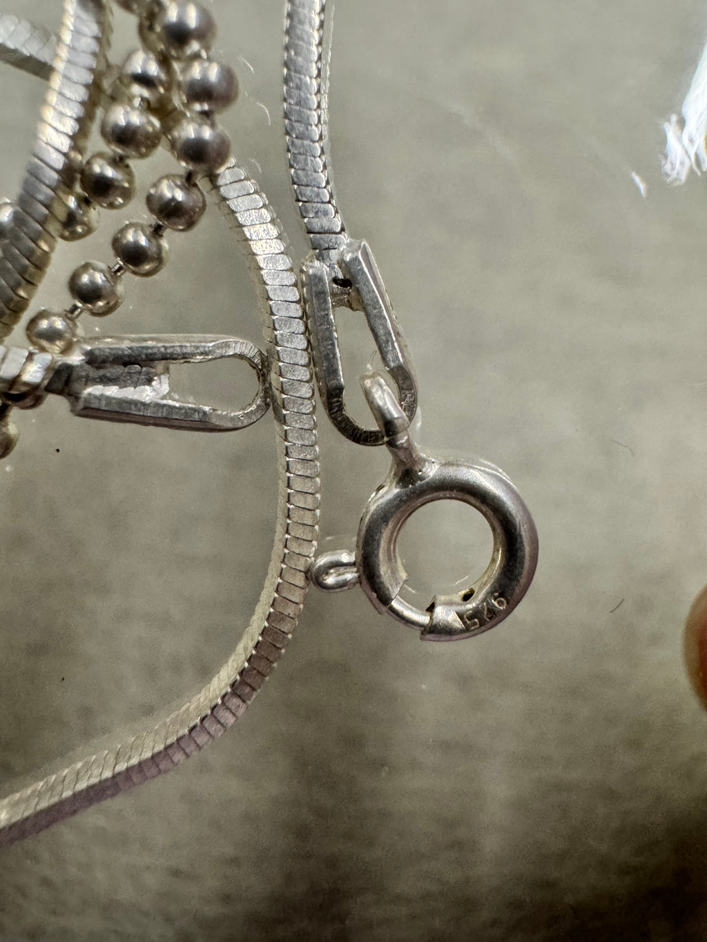 Spring ring clasp stamped 925 and the flat end tag on the sterling silver bead and snake chain necklace.