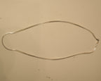The silver foxtail chain laid out in a long oval to show how it falls.