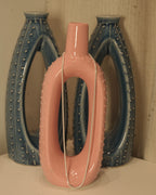 The silver snake chain hung over a pink ceramic vase.