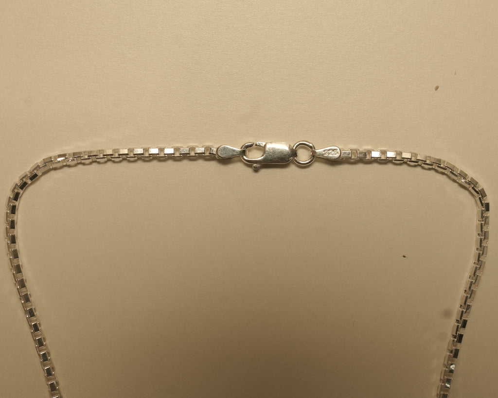Close view of the lobster clasp on the silver box chain.
