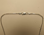 Close view of the lobster clasp on the silver box chain.