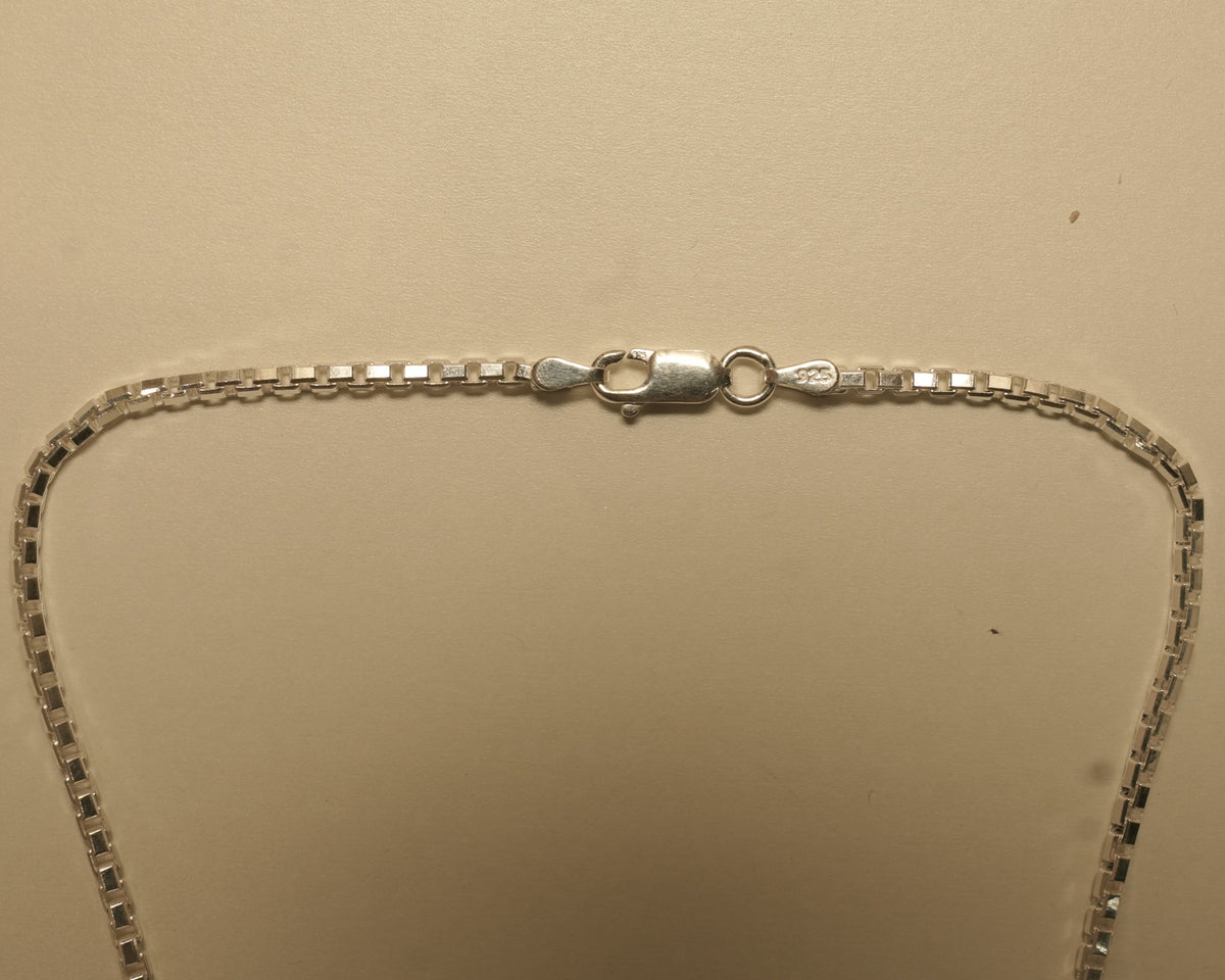 Close view of the lobster clasp on the silver box chain.