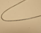 Close view of the square box links along the silver chain.