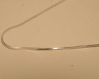 Close view of the flat snake links along the silver chain.