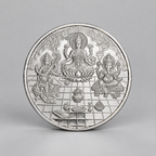 10 gram fine silver coin with Lakshmi on a lotus between Ganesh and Saraswati, on a grey surface.