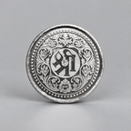 Reverse of the 10 gram silver coin with Shri in Devanagari inside a floral border.