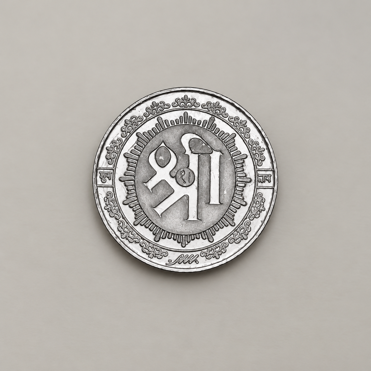 Reverse of the 20 gram silver coin with Shri in Devanagari inside a rayed border.