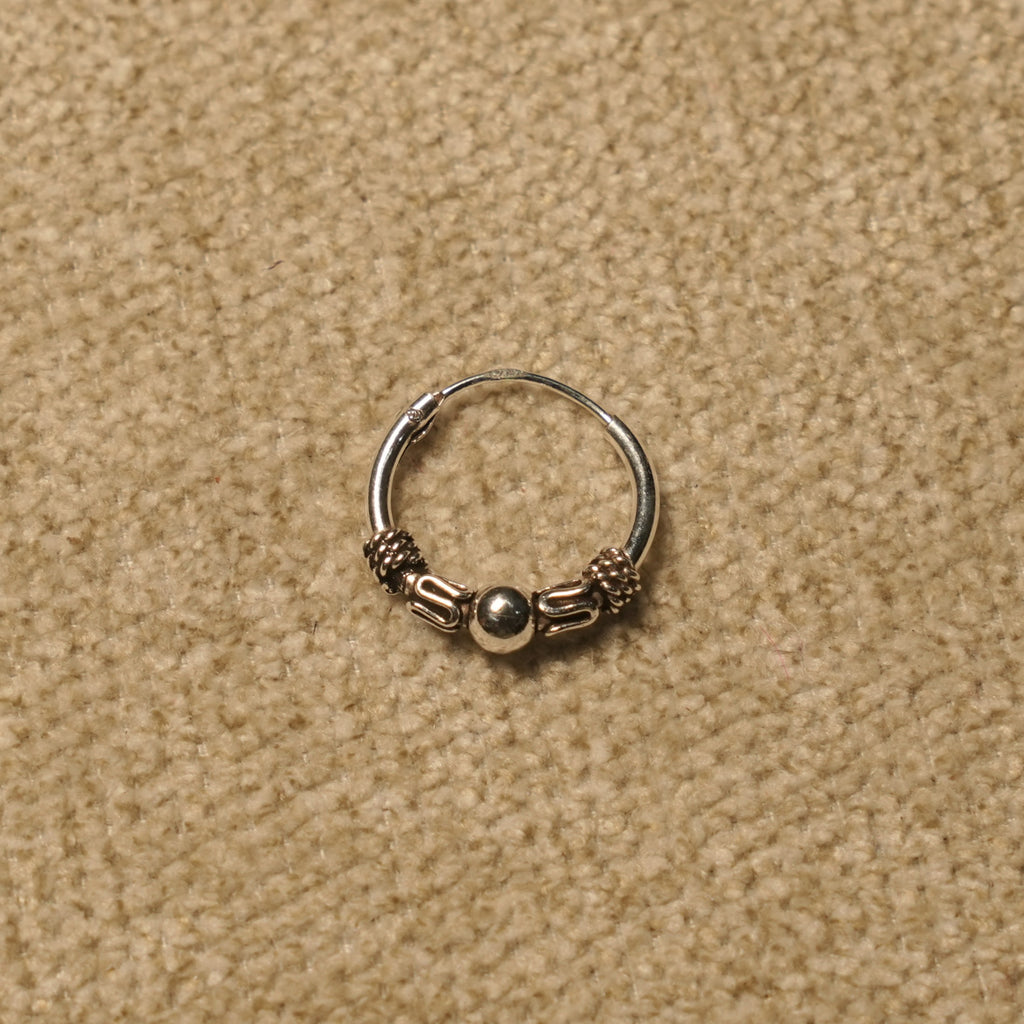 Single beaded Bali hoop in sterling silver showing the rope coil and scroll detailing around the centre bead.