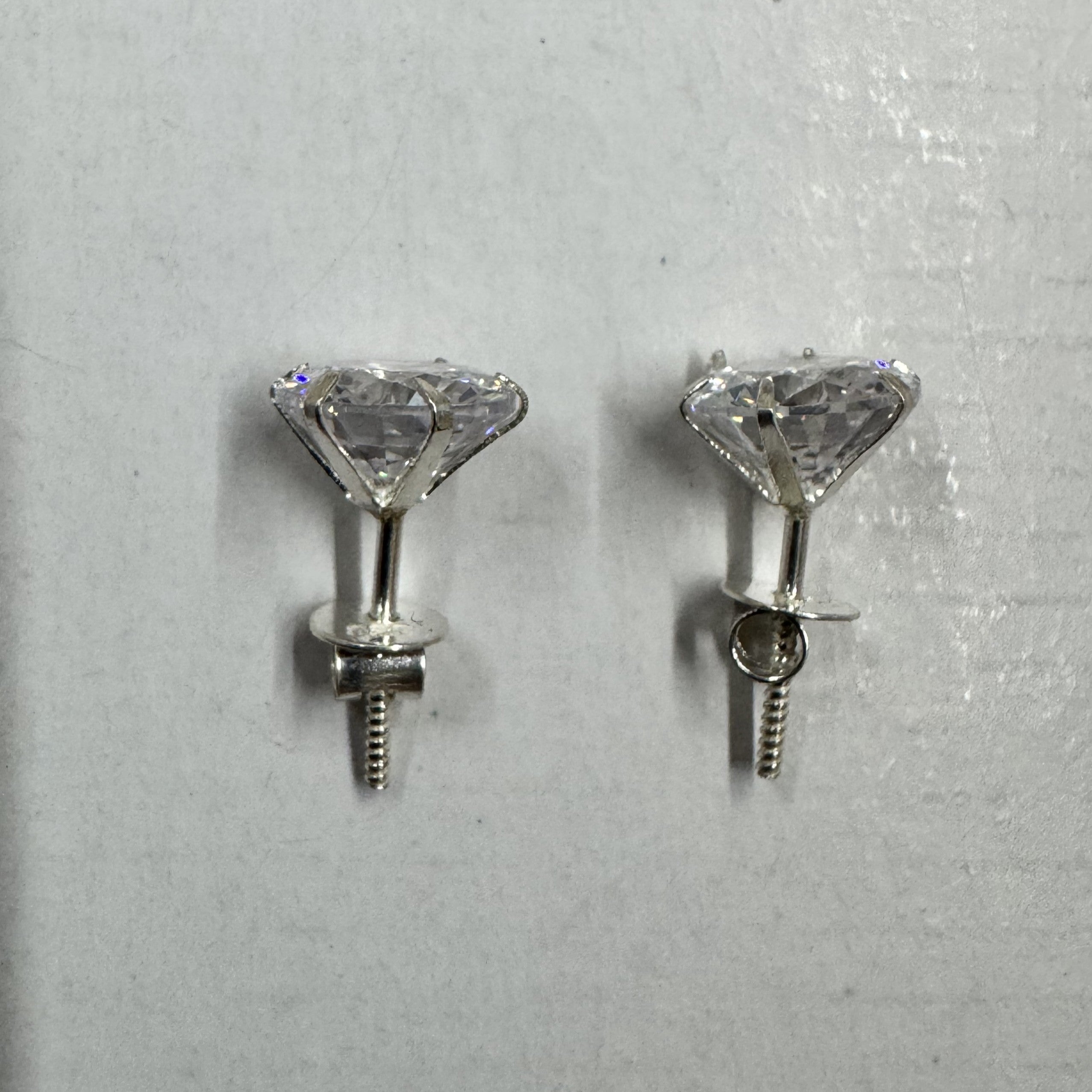 Side view of the sterling silver stud earrings, showing the tapered claw baskets, threaded posts and screw-on backs.