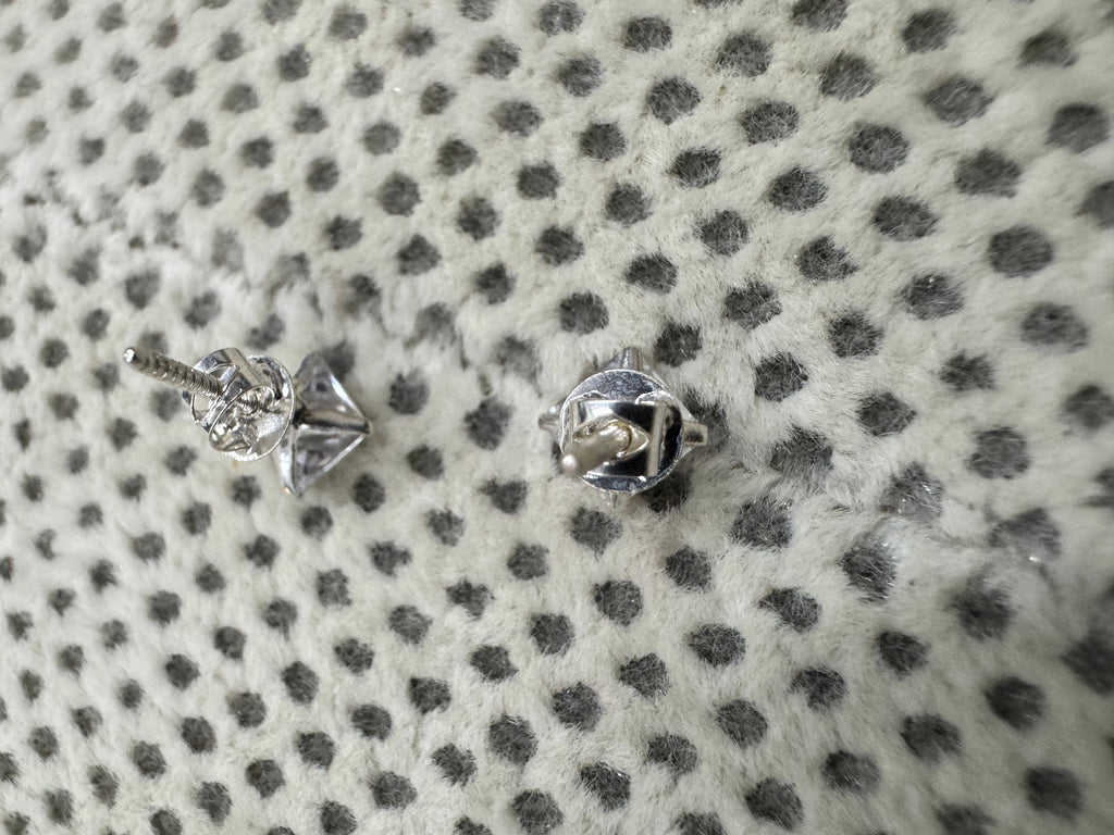 Reverse of the sterling silver cubic zirconia studs, showing the open four-claw basket, the threaded post and the screw back.