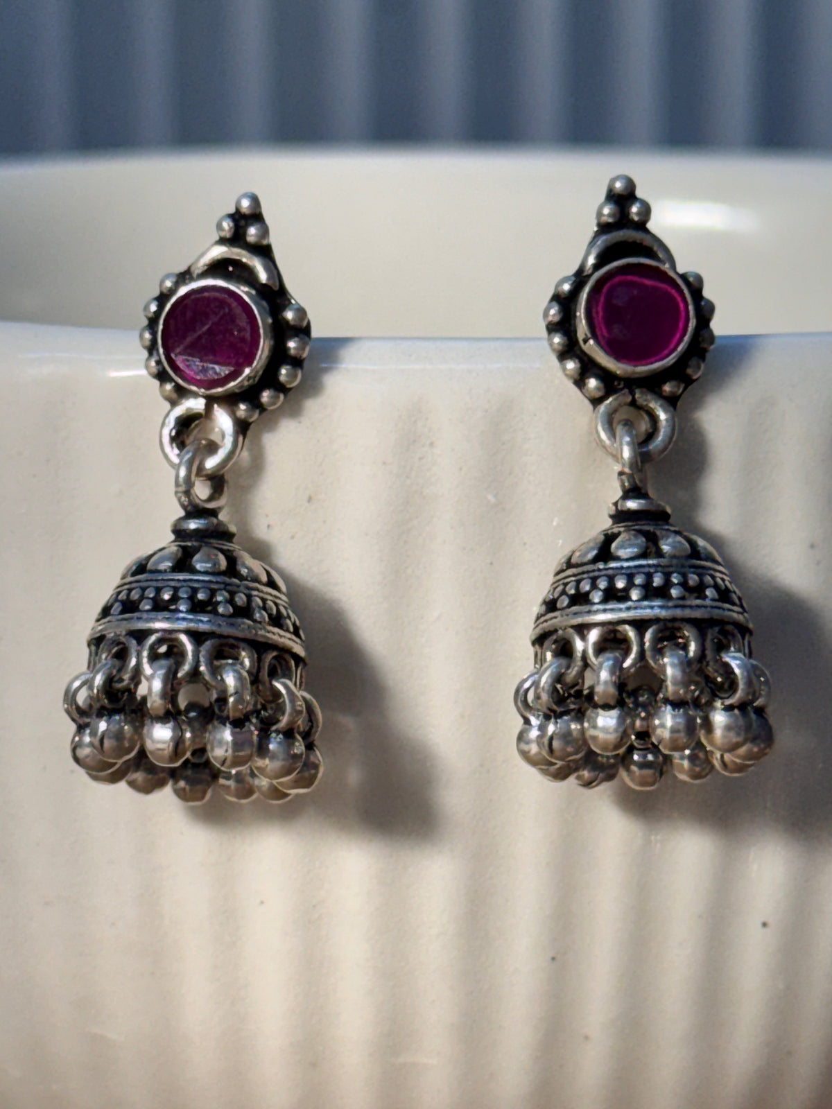 Both dome styles of the oxidised pink stone jhumkas placed side by side for comparison.