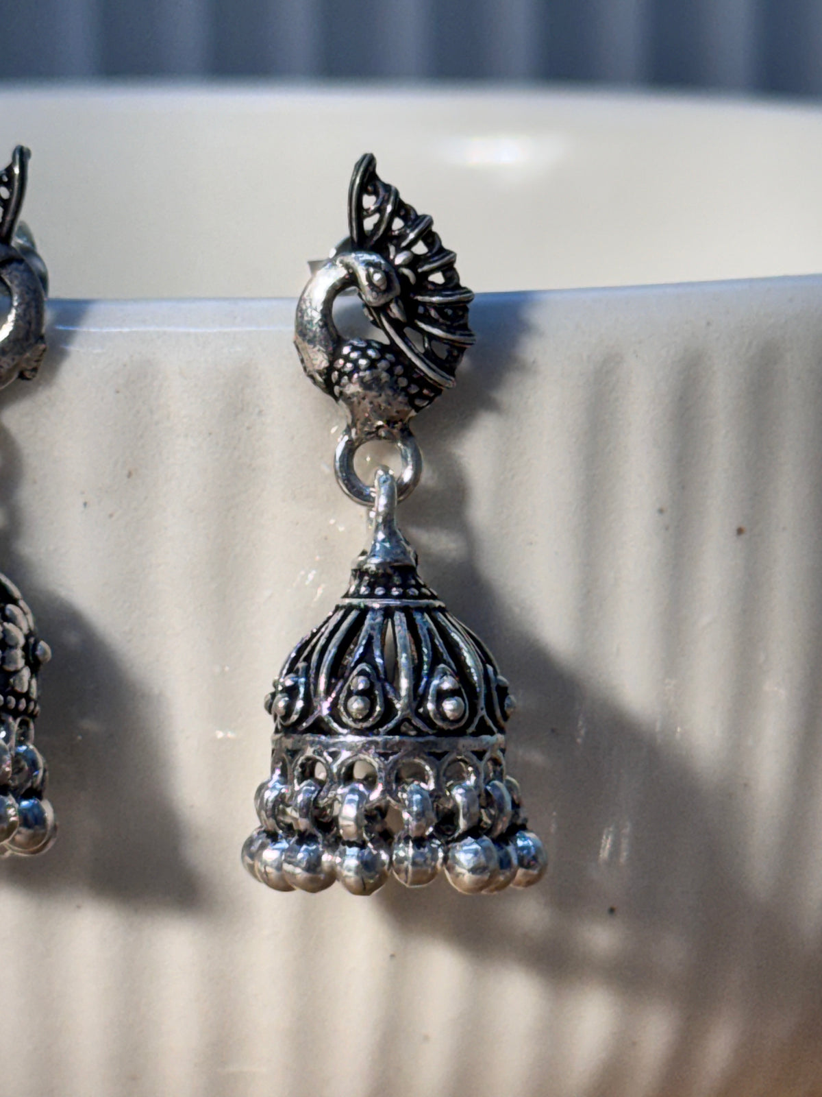 Oxidised sterling silver peacock stud jhumka with a floral granule dome.