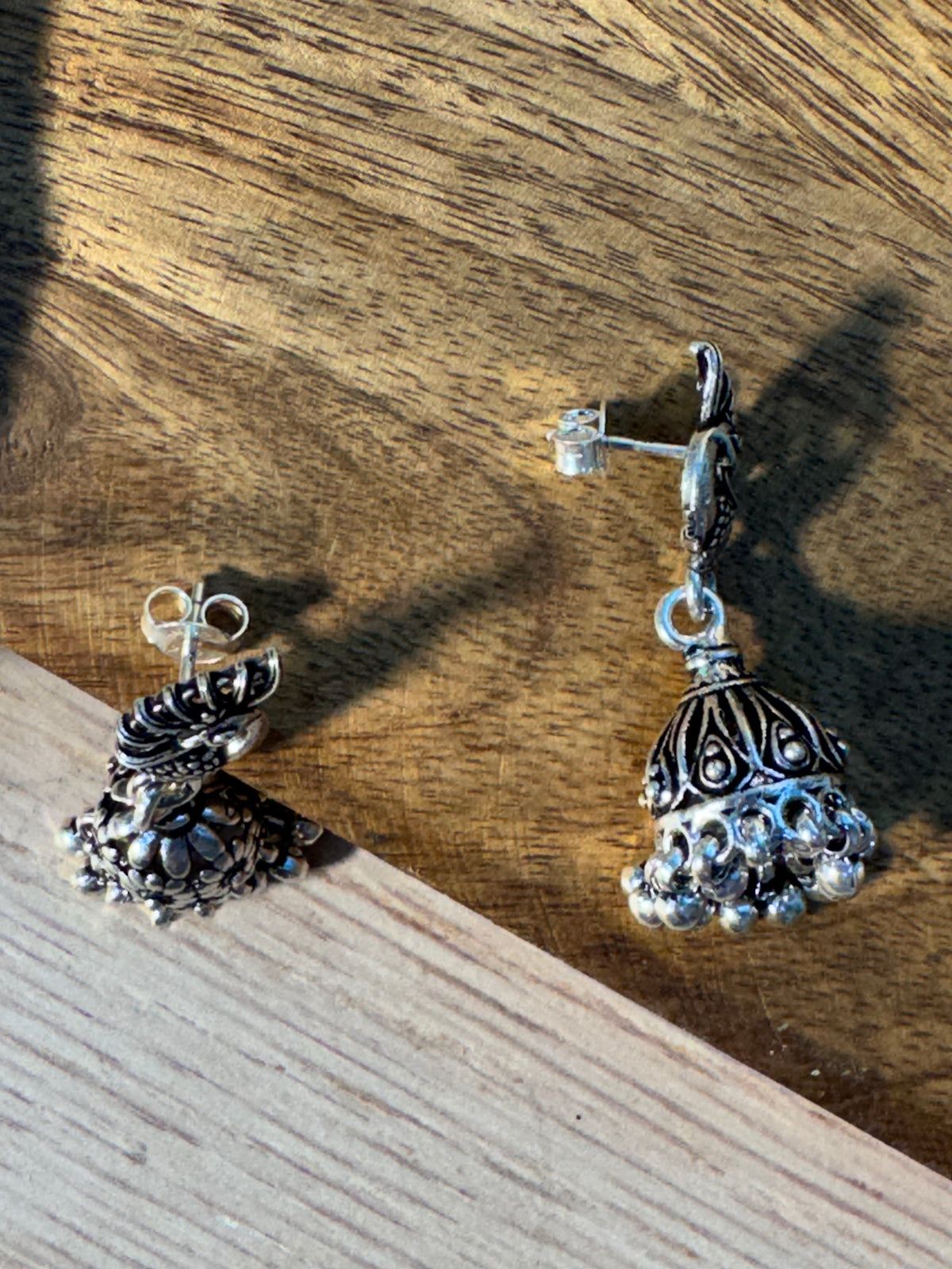 Back of the oxidised peacock jhumkas, showing the posts and the hollow of the domes.