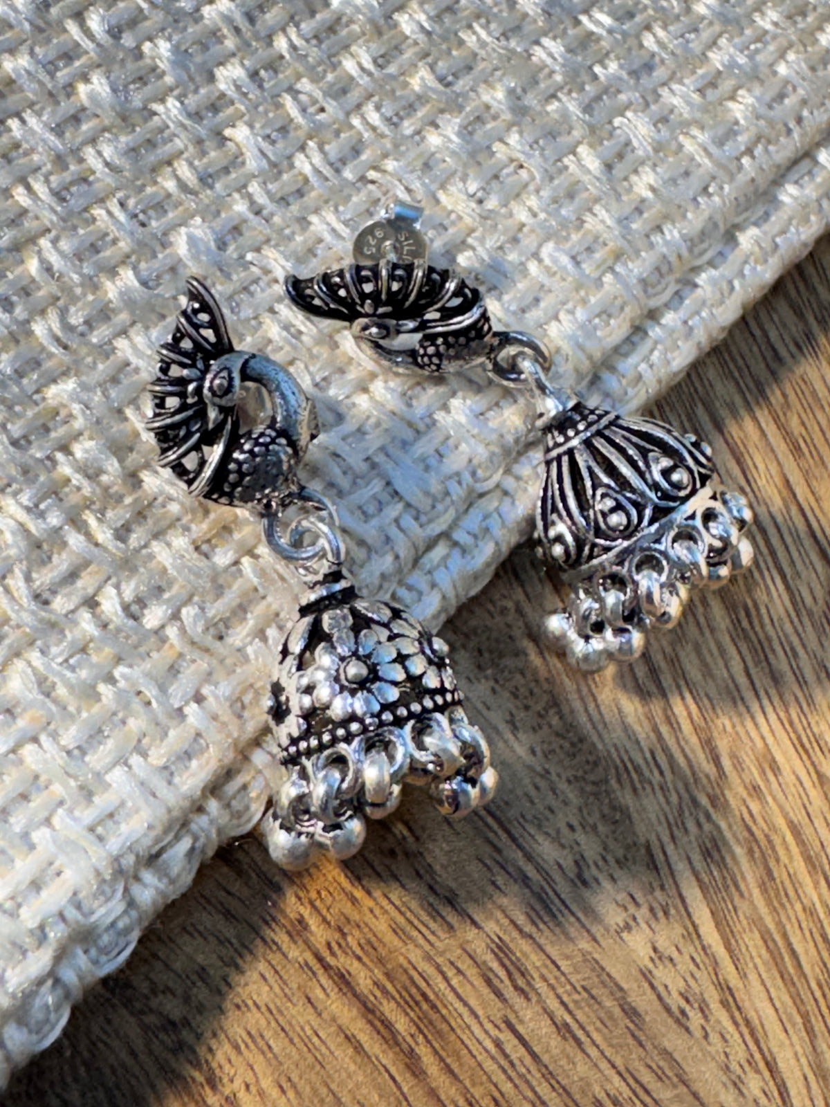 Both dome styles of the oxidised peacock jhumkas placed together for comparison.