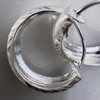 Close view of the faceted edges and the hinged closure of the silver hoops.