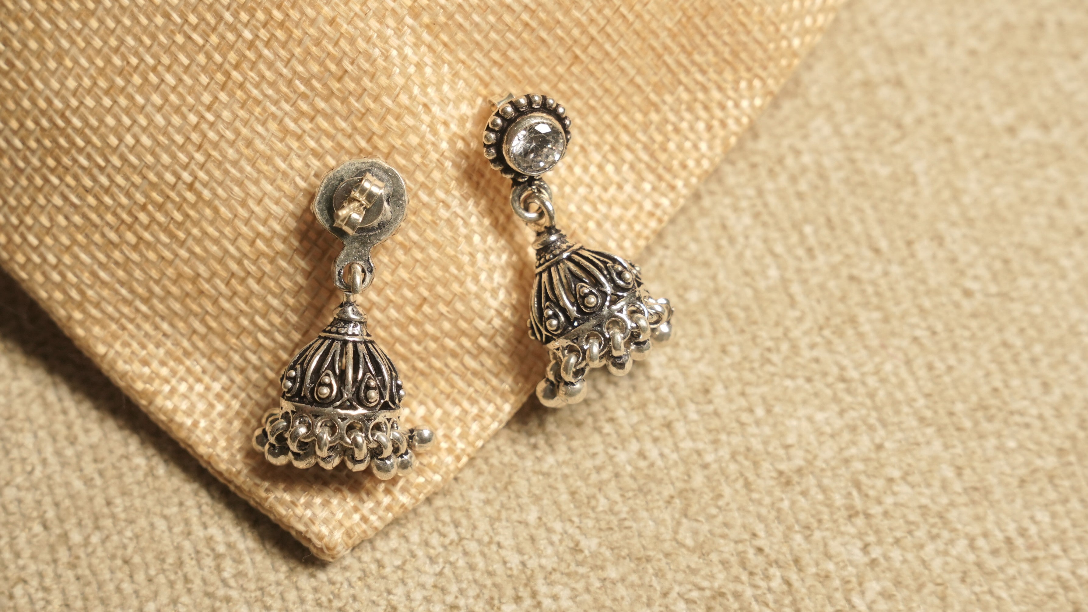 Front and back view of the cubic zirconia jhumka earrings, showing the butterfly post and bead-fringed bell drop.