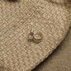 Ribbed sterling silver huggie hoop earrings shown against a natural woven jewellery pouch.