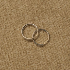 Close view of the slim sterling silver hoops showing the fine round-wire profile and hinged closure.